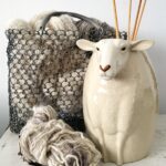 Vaas schaap wit. gevuld met breinaalden samen met hand gesponnen wol