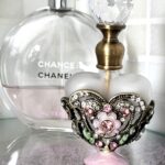 Parfumflesje bloementjes zachtroze geëmailleerd, sfeerfoto